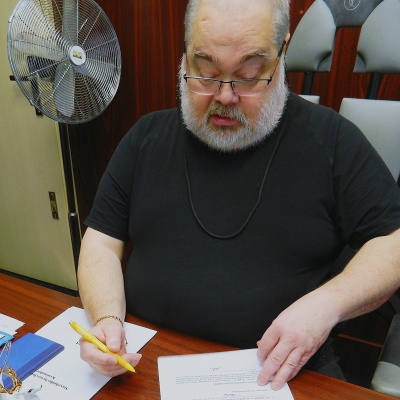 ředitel František Ryba čte dokument a v ruce má tužku
